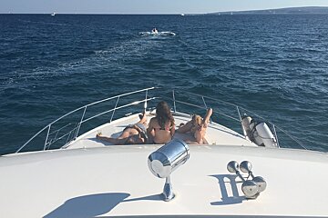 girls sunbating on front of a yacht at sea in mallorca